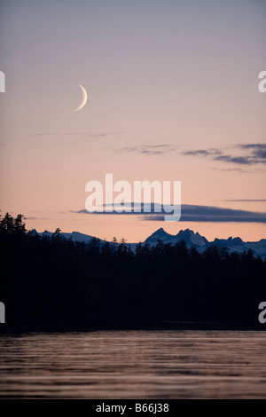 Stati Uniti d'America Alaska Tongass National Forest Crescent Moon imposta al di sopra dei picchi di montagna di Baranof Island Foto Stock