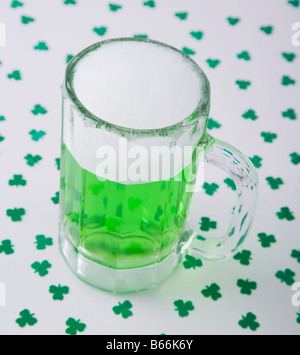 Bicchiere di birra verde per la festa di San Patrizio e trifogli Foto Stock