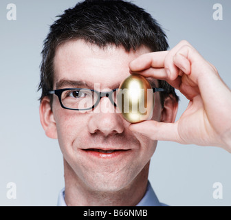 Mid-Adult Uomo con uovo al suo occhio Foto Stock