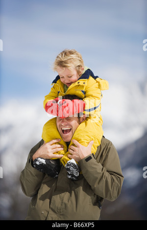 Ragazzo sulle spalle dei padri Foto Stock