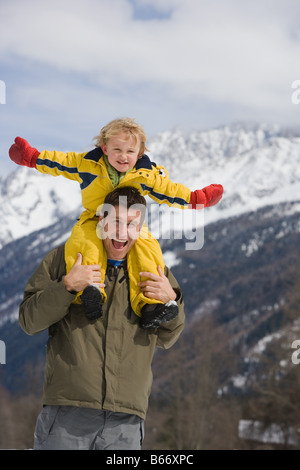 Ragazzo sulle spalle dei padri Foto Stock