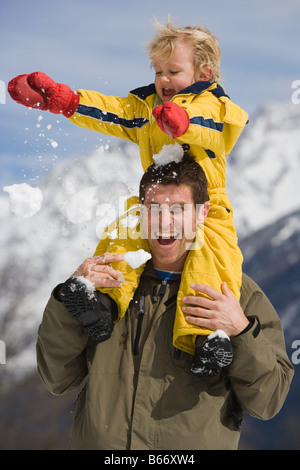 Ragazzo sulle spalle dei padri Foto Stock