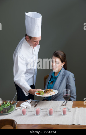 Lo chef serve una donna con un pasto Foto Stock