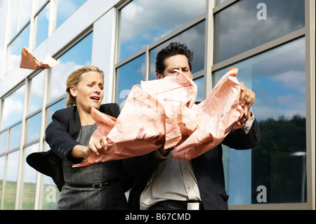 La gente di affari con i giornali in vento Foto Stock