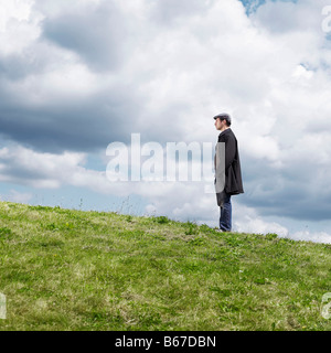 Lone uomo in piedi sulla collina Foto Stock