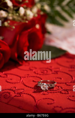 Anello di fidanzamento sulla casella rossa e le rose Foto Stock