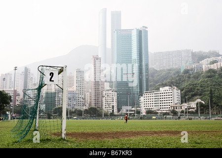 Alti grattacieli come visto attraverso un campo sportivo nel centro di della città di Hong Kong Foto Stock