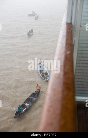 Ringhiera di MS Europa e degli indiani d'Amazzonia in canoa durante un acquazzone di pioggia sul fiume Rio delle Amazzoni, Boca da Valeria, Amazonas, Brazi Foto Stock