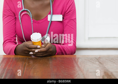 Medico tenendo una bottiglia di pillole Foto Stock