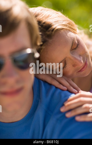 Donna pendente sulla testa di uomo con la schiena Foto Stock