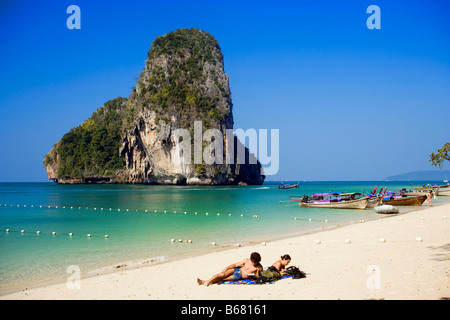 I turisti giacente in corrispondenza di spiaggia di sabbia bianca, ricoperta di chalk cliff in background, Phra Nang Beach, Laem Phra Nang, Railay, Krabi, Thailandi Foto Stock