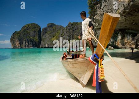 Boatman in piedi su di una barca dalla coda lunga e tenendo una corda, Maya Bay, una bellissima SCENIC LAGUNA, famoso per il film di Hollywood " Foto Stock