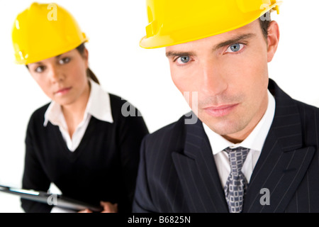 Una messa a fuoco selettiva concetto industriale shot che mostra un uomo e donna vestita di copricapi rigidi il focus è sul uomo in primo piano Foto Stock