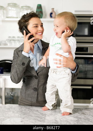 La madre e il bambino figlio di parlare su dispositivi mobili Foto Stock
