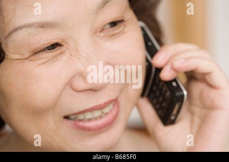 Close-up di una donna matura a parlare su un telefono mobile e sorridente Foto Stock