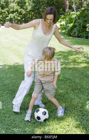 La madre e il figlio che giocano a calcio Foto Stock