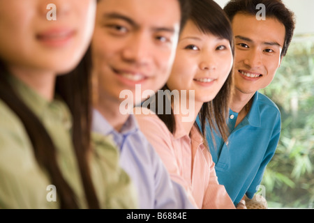 Close-up di due giovani uomini e due giovani donne sorridente Foto Stock