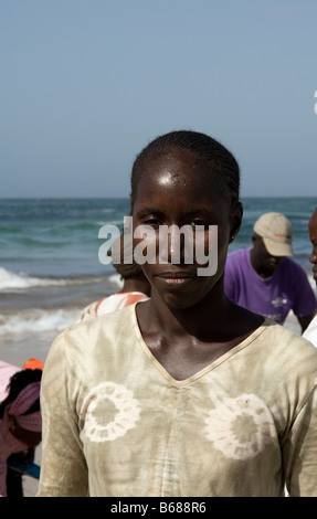 Donna acquisto appena sbarcato pesce al mercato del pesce sulla spiaggia di Yoff Dakar in Senegal Foto Stock