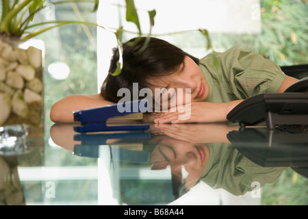 Femmina di lavoratore di ufficio napping in una tabella Foto Stock