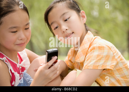 Due ragazze guardando a un telefono cellulare Foto Stock