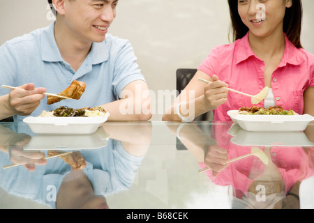 Due lavoratori ufficio avente il pranzo e sorridente Foto Stock