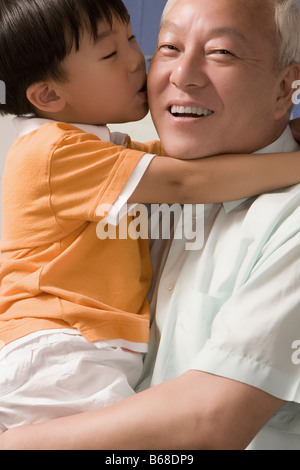 Close-up di un ragazzo baciare il nonno Foto Stock