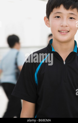 Ritratto di un adolescente in piedi in un corridoio e sorridente Foto Stock