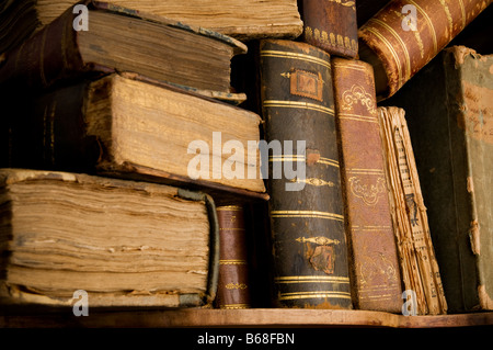 Molto vecchio e polveroso dorso dei libri in un heap su uno scaffale Foto Stock