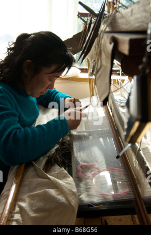 Donna artigiano concentrando sulla tessitura di tappezzeria in seta a Suzhou ricamo Istituto di Ricerca nella montagna Huanxiu Villa Foto Stock