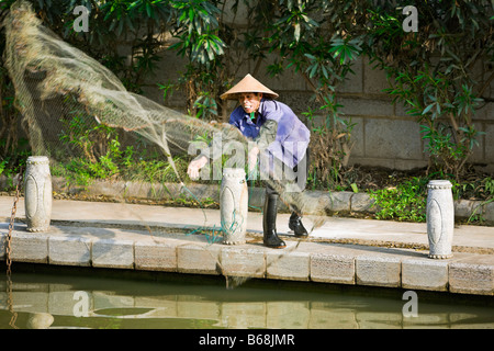 Pescatore di gettare una rete da pesca in un lago, Guilin, provincia di Guangxi, Cina Foto Stock