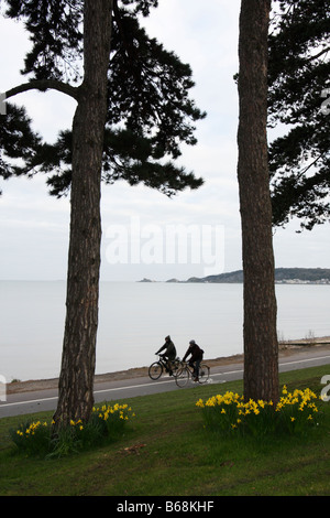 Vista da ovest attraversare la Mumbles, Swansea, West Glamorgan, South Wales, Regno Unito, con due ciclisti in primo piano Foto Stock