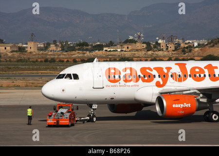 Easyjet aerei Boeing essendo spinto al di fuori della zona di parcheggio mediante l'aviosuperficie veicolo di servizio pronto a decollare. Foto Stock