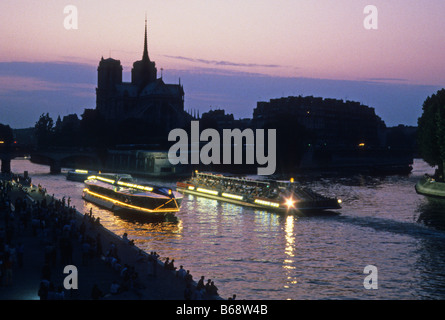 Bateaux Mouche imbarcazioni turistiche passano la cattedrale di Notre Dame sul Fiume Senna, Parigi Foto Stock