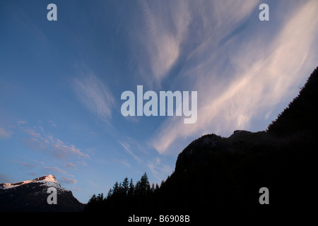 Stati Uniti d'America Alaska Misty Fjords National Monument impostazione sole illumina le nuvole sopra la foresta pluviale su scogliere lungo Rudyerd Bay Foto Stock