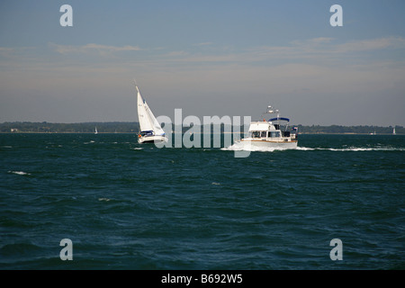 Imbarcazione a motore e yacht nel Solent fuori Yarmouth harbour Isle of Wight England Regno Unito Foto Stock