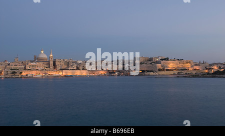 La Valletta skyline nel porto di Marsamxett dopo il tramonto con la Cattedrale Anglicana di San Paolo e la cupola della chiesa carmelitana (Nostra Signora del Monte Carmelo), Sant'Andrea il bastione a destra, da Sliema Creek fronte mare a Malta Foto Stock