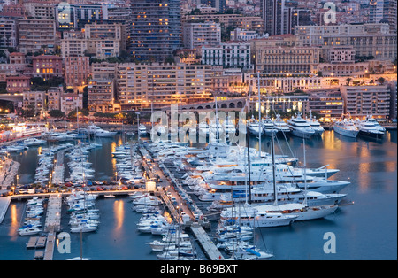 Panoramica il Principato di Monaco e Monte Carlo, porto con barche di lusso e le navi al tramonto, Francia, Europa UE Foto Stock