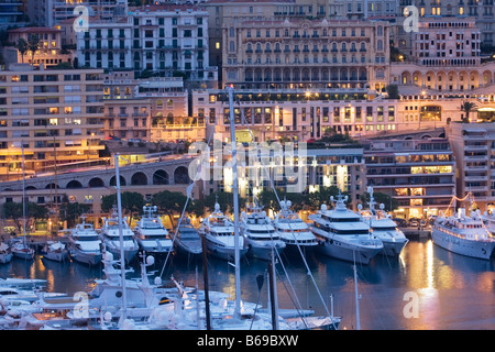 Panoramica il Principato di Monaco e Monte Carlo, porto con barche di lusso e le navi al tramonto, Francia, Europa UE Foto Stock