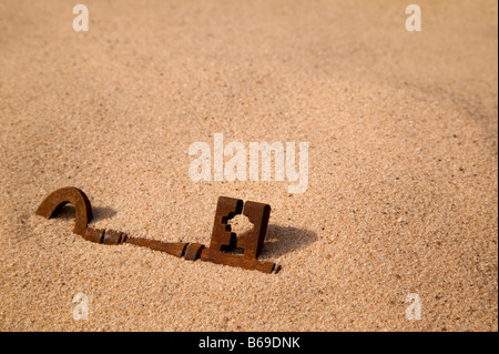 Un arrugginito vecchia chiave sepolto nella sabbia Foto Stock