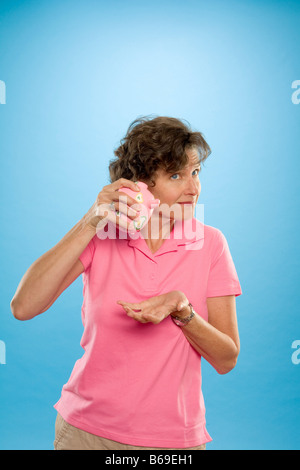 La donna sta tentando di ottenere il denaro di un salvadanaio Foto Stock