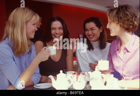 Quattro giovani donne conversando davanti ad una tazza di tè Foto Stock