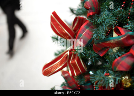 Persona che cammina passato albero di Natale nel centro commerciale per lo shopping Foto Stock