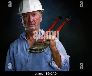 Costruzione caucasica lavoratore con bullone hardhat taglierine in studio - USA Foto Stock