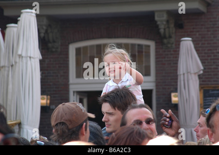 Giovane ragazza su daddy's spalle in udienza a evento esterno Foto Stock