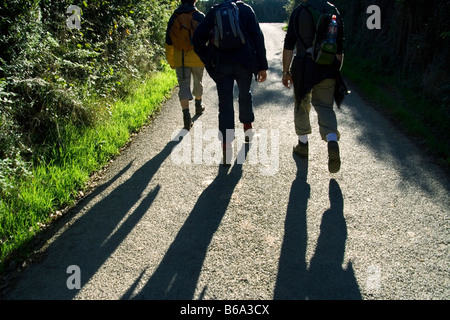 Walkers sul paese strada in Cornwall, Regno Unito Foto Stock