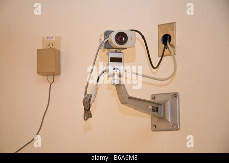 La sicurezza di una videocamera di sorveglianza su base girevole con cavo di alimentazione proveniente dall'alto. Foto Stock