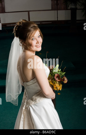 Sposa guardando sopra la spalla verso la fotocamera da dietro Foto Stock