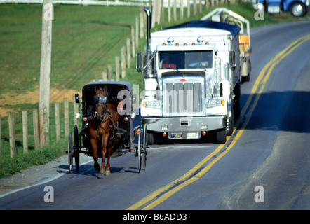 Amish cavallo buggy su una strada rurale rallenta un rimorchio di un trattore, Lancaster County, Pennsylvania, STATI UNITI D'AMERICA Foto Stock