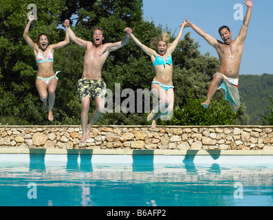Gli amici il salto in piscina Foto Stock