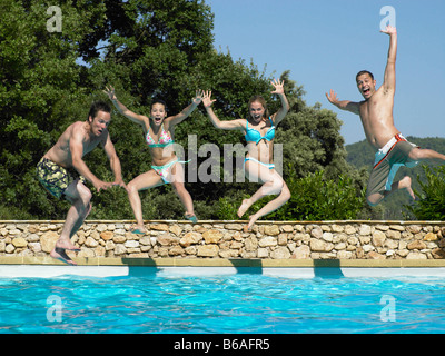 Gli amici il salto in piscina Foto Stock